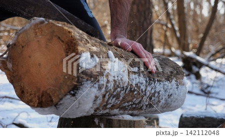 Male hand sawing a log in sunny winter forest. Strong guy working with a saw in snowy woodland. Concept of strength, masculine, energy, and harmony with nature during cold season. Slow motion Male hand sawing a log in sunny winter forest. Strong guy working with a saw in snowy woodland. Concept of strength, masculine, energy, and harmony with nature during cold season. Slow motion 142112048