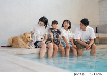 プールで犬と一緒に遊ぶ家族 プールで犬と一緒に遊ぶ家族 142112076