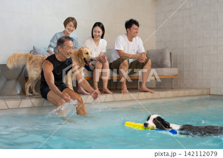 愛犬とプールで遊ぶ大人の家族旅行 142112079