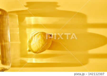 Lemon and refreshing drinking water on yellow background Lemon and refreshing drinking water on yellow background 142112307