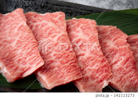 サシの入った国産黒毛和牛のモモ肉(トモサンカク)のスライスのクローズアップ サシの入った国産黒毛和牛のモモ肉(トモサンカク)のスライスのクローズアップ 142113273