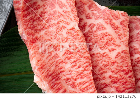 サシの入った国産黒毛和牛のモモ肉（トモサンカク）のスライスのクローズアップ 142113276