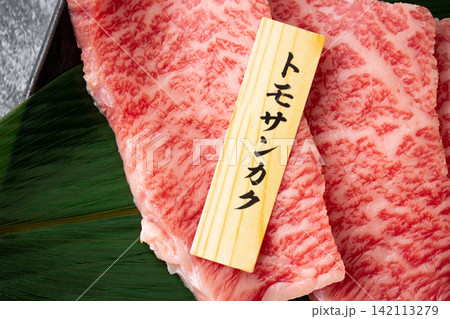 サシの入った国産黒毛和牛のモモ肉(トモサンカク)のスライスのクローズアップ サシの入った国産黒毛和牛のモモ肉(トモサンカク)のスライスのクローズアップ 142113279