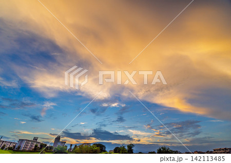 明るい夕焼け雲が広がるファンタスティックな夏の風景 明るい夕焼け雲が広がるファンタスティックな夏の風景 142113485