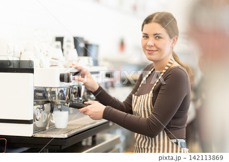 Girl coffee shop employee at work Girl coffee shop employee at work 142113869