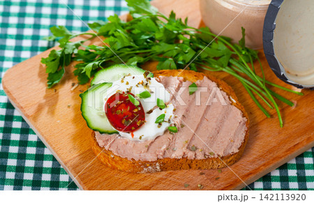 Toast with pate, fresh cheese on wooden board 142113920