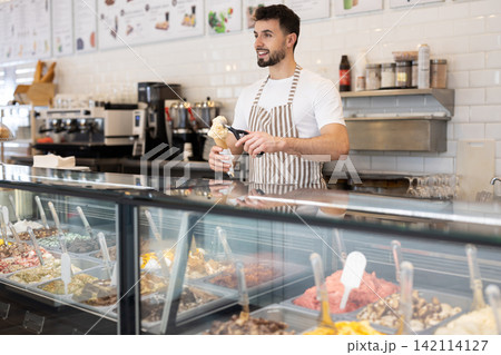 guy working in a cafe offers ice cream guy working in a cafe offers ice cream 142114127