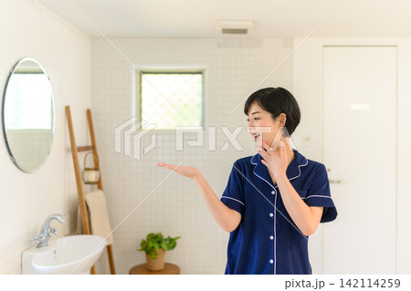 洗面所で鏡を見る若い日本人女性 142114259