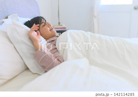 朝の寝室で気持ちよく眠る女性の穏やかな表情 朝の寝室で気持ちよく眠る女性の穏やかな表情 142114285