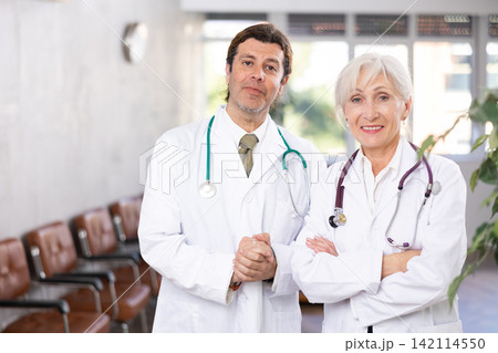 Two experienced professional doctors standing in medical office Two experienced professional doctors standing in medical office 142114550