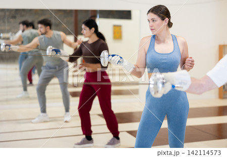 Young woman is engaged in fencing in a modern sports club 142114573