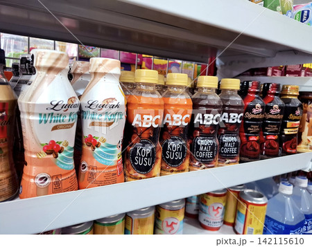 Rows of ready-to-drink coffee and malt beverages in different flavors and sizes displayed for sale in a retail store. Rows of ready-to-drink coffee and malt beverages in different flavors and sizes displayed for sale in a retail store. 142115610