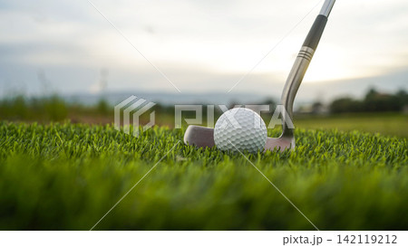 Golf clubs and balls on a green lawn in a beautiful golf course with morning sunshine. 142119212