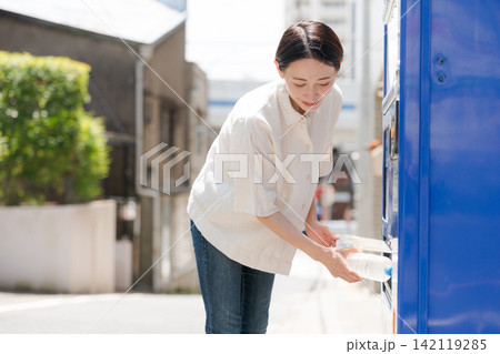 自販機で水を買う女性 142119285