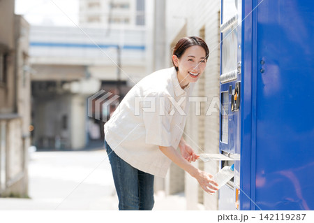 自販機で水を買う女性 142119287
