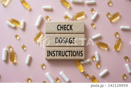 CHECK DOSAGE INSTRUCTIONS symbol. Concept words CHECK DOSAGE INSTRUCTIONS on wooden blocks. Beautiful pink background with pills. Healthcare and CHECK DOSAGE INSTRUCTIONS concept. Copy space. CHECK DOSAGE INSTRUCTIONS symbol. Concept words CHECK DOSAGE INSTRUCTIONS on wooden blocks. Beautiful pink background with pills. Healthcare and CHECK DOSAGE INSTRUCTIONS concept. Copy space. 142120959