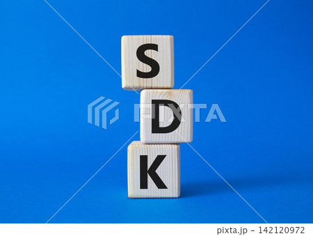 SDK - software development kit. Wooden cubes with word SDK . Beautiful blue background. Business and software development kit concept. Copy space. SDK - software development kit. Wooden cubes with word SDK . Beautiful blue background. Business and software development kit concept. Copy space. 142120972