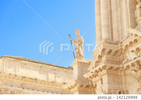 grand stone facade religious building classical columns ornate carvings and prominent sculpture of pope 142120998
