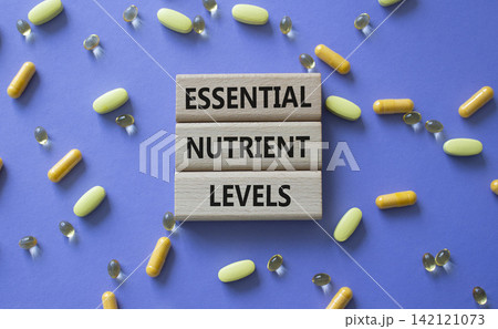 Essential nutrient levels symbol. Concept words Essential nutrient levels on wooden blocks. Beautiful purple background with pills. Healthcare and Essential nutrient levels concept. Copy space. 142121073