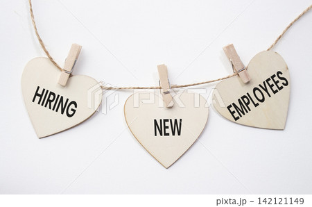 Hiring New Resources text on wooden heart tags hanging on rope with clothespins over white background. Recruitment and workforce expansion concept with copy space. Hiring New Resources text on wooden heart tags hanging on rope with clothespins over white background. Recruitment and workforce expansion concept with copy space. 142121149