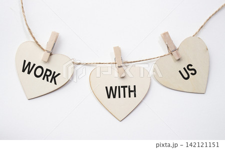 Work With Us text on wooden heart tags hanging on rope with clothespins over white background. Recruitment, employment and career opportunity concept with copy space. 142121151