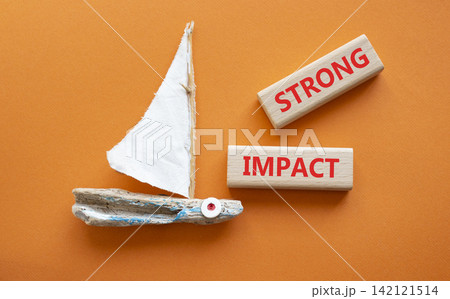 STRONG IMPACT symbol. Concept word STRONG IMPACT on wooden blocks. Beautiful orange background with boat. Business and STRONG IMPACT concept. Copy space STRONG IMPACT symbol. Concept word STRONG IMPACT on wooden blocks. Beautiful orange background with boat. Business and STRONG IMPACT concept. Copy space 142121514
