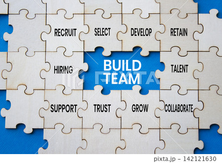 Build team symbol. Concept words build team on wooden puzzle pieces over blue background. Talent puzzle piece. Beautiful blue background. Team building concept. Copy space. Build team symbol. Concept words build team on wooden puzzle pieces over blue background. Talent puzzle piece. Beautiful blue background. Team building concept. Copy space. 142121630