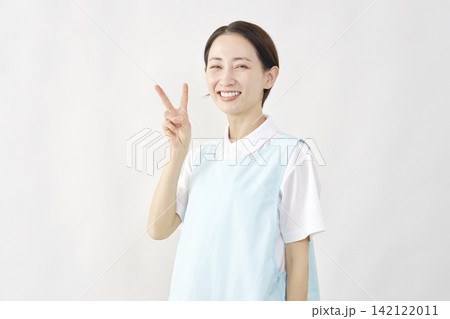 介護士女性　ピースサイン　白背景 142122011