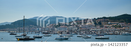 Panorama of the port of Baiona with anchored sailboats and the town on the hillside Panorama of the port of Baiona with anchored sailboats and the town on the hillside 142123357