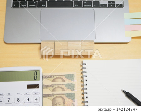 ノートパソコン、電卓、ノート、日本円と付箋 ノートパソコン、電卓、ノート、日本円と付箋 142124247