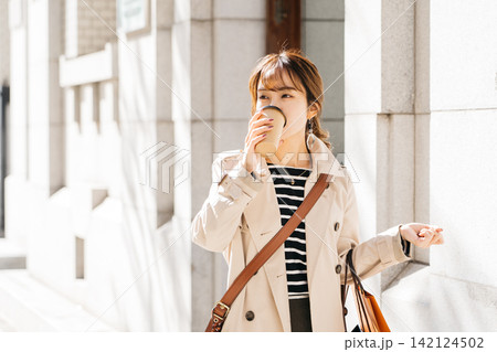 屋外でコーヒーを飲む女性 142124502