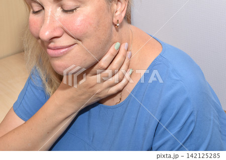 The woman has a sore throat. 142125285