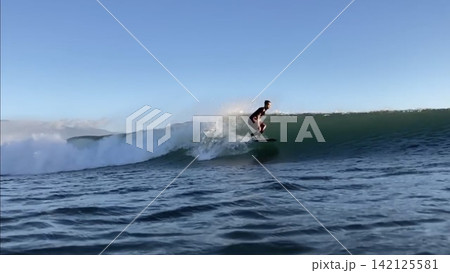 輝く波を切るサーファーのシルエット 輝く波を切るサーファーのシルエット 142125581