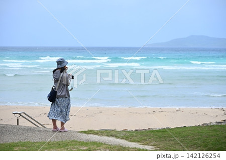綺麗なエメラルドグリーンの海を撮影する女性 綺麗なエメラルドグリーンの海を撮影する女性 142126254