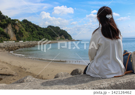 青い海と砂浜を堤防から眺める女性 青い海と砂浜を堤防から眺める女性 142126462