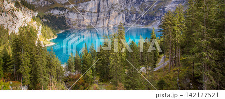 Oeschinensee Kandersteg Swiss Alps Switzerland turquoise mountain lake surrounded by pine forest and steep rocky cliffs Oeschinensee Kandersteg Swiss Alps Switzerland turquoise mountain lake surrounded by pine forest and steep rocky cliffs 142127521