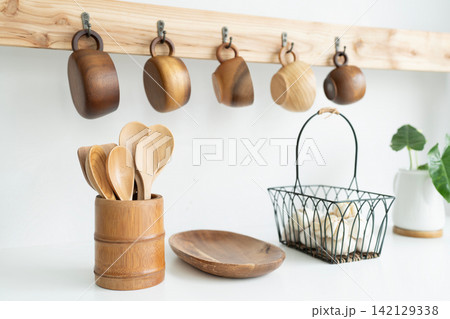Wooden cup hanging, wooden utensil and garlic in a basket Wooden cup hanging, wooden utensil and garlic in a basket 142129338