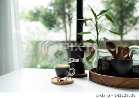 Coffee and moka pot set arranged on white table, morning relaxing routine Coffee and moka pot set arranged on white table, morning relaxing routine 142129339