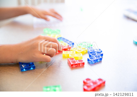 パズルブロックで遊ぶ子供の手元 パズルブロックで遊ぶ子供の手元 142129811