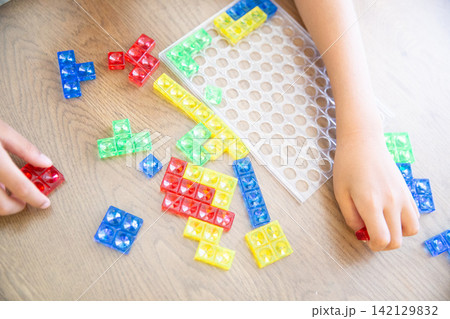 カラフルなブロックパズルで遊ぶ子供の手元 カラフルなブロックパズルで遊ぶ子供の手元 142129832