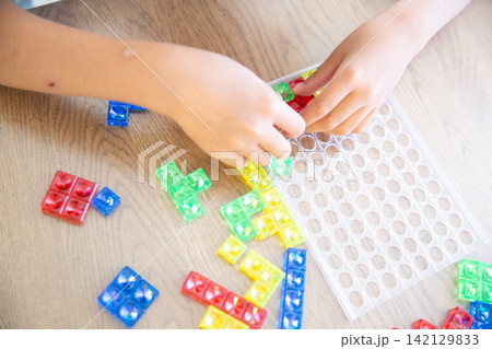カラフルなブロックパズルで遊ぶ子供の手元 カラフルなブロックパズルで遊ぶ子供の手元 142129833