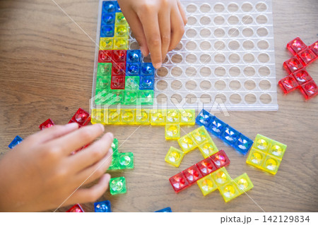 カラフルなブロックパズルで遊ぶ子供の手元 カラフルなブロックパズルで遊ぶ子供の手元 142129834
