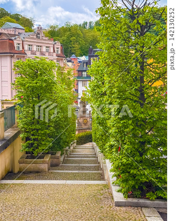 View of a pathway in Karlovy Vary surrounded by trees and buildings 142130252