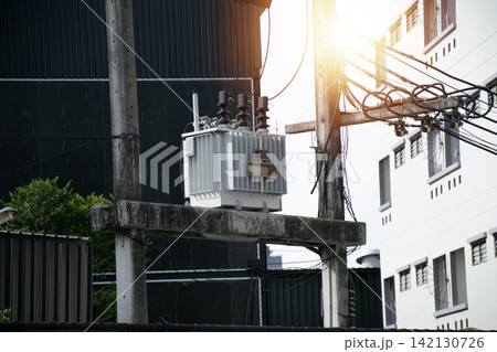 Electricity distribution transformer mounted on a utility pole with multiple wires connected, electricity 142130726
