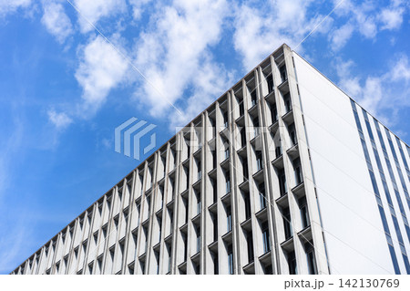 Low angle view of modern concrete office building facade with geometric pattern under cloudy sky in Fukuoka, Japan 142130769