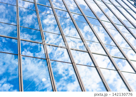 Low angle view of modern glass office building facade reflecting cloudy sky in Fukuoka, Japan Low angle view of modern glass office building facade reflecting cloudy sky in Fukuoka, Japan 142130776