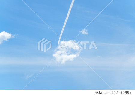 青空に一直線に伸びる飛行機雲と白い雲 青空に一直線に伸びる飛行機雲と白い雲 142130995