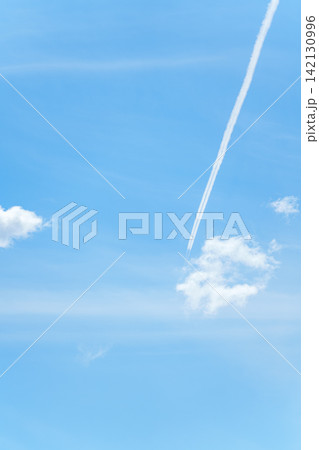 青空に一直線に伸びる飛行機雲と白い雲 青空に一直線に伸びる飛行機雲と白い雲 142130996