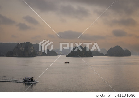 Halong Bay in Vietnam in the early morning before sunrise. Dawn view of Halong Bay with small boats. Halong Bay in Vietnam in the early morning before sunrise. Dawn view of Halong Bay with small boats. 142131080