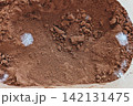 Raw cocoa powder with white fuzzy mold growth, dry clumps and granular texture shown in extreme close-up, visible food spoilage and contamination 142131475